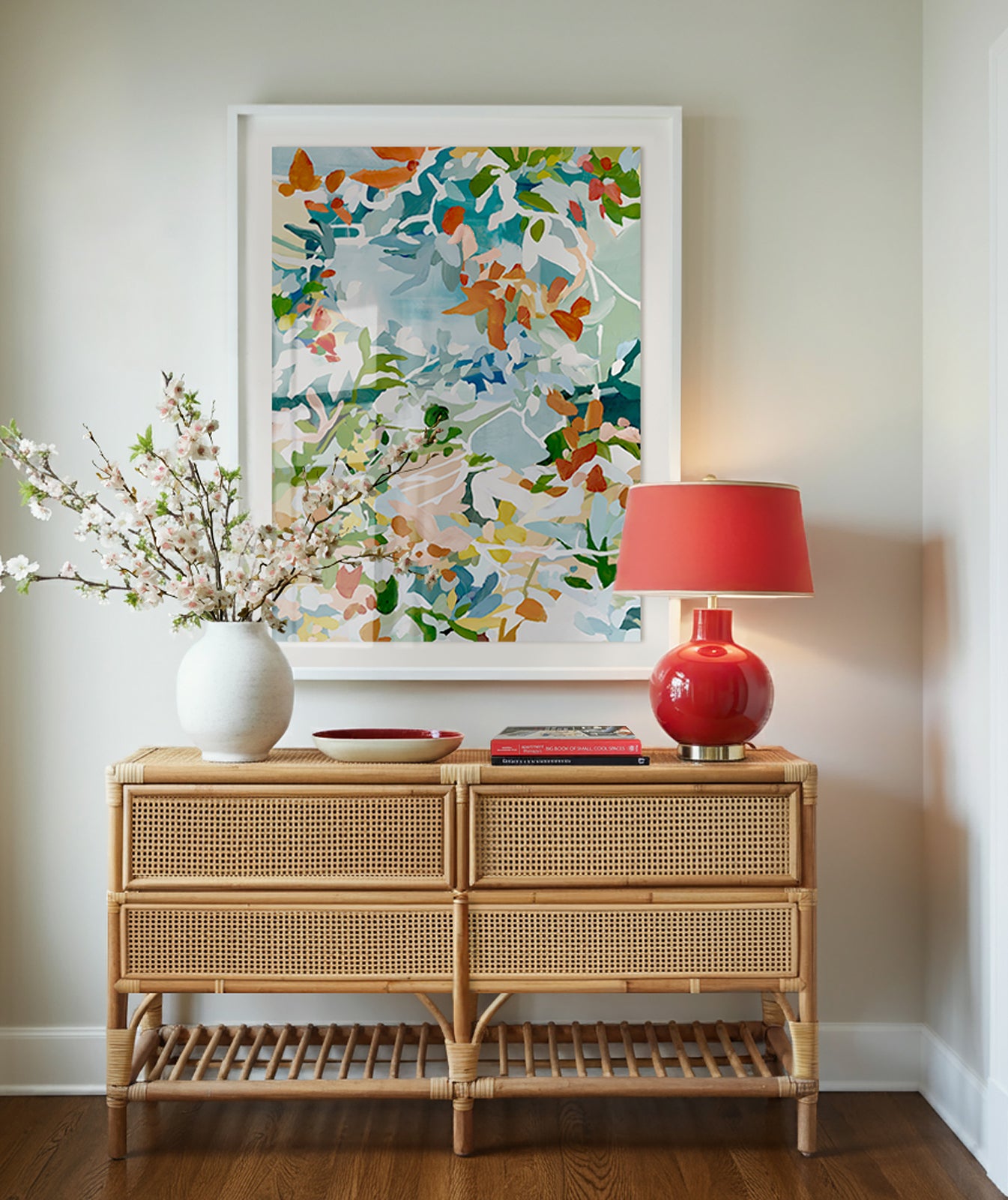 Colorful large abstract floral artwork in reds, greens, blues, yellow, and pinks, displayed above a console table in an entryway.