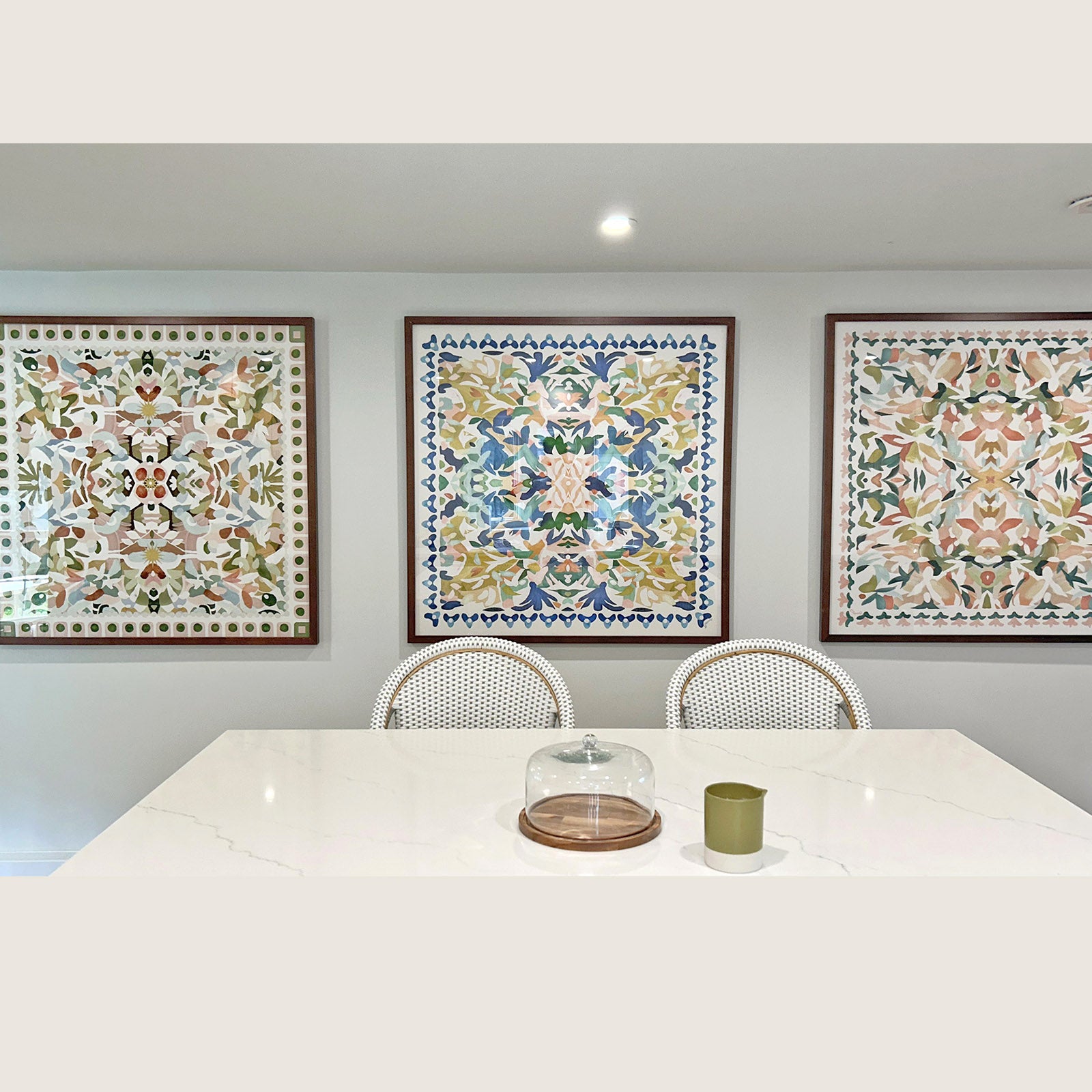 Customer photo featuring three colorful, kaleidoscopic 40 x 40" fine art prints displayed side by side in a white kitchen setting.