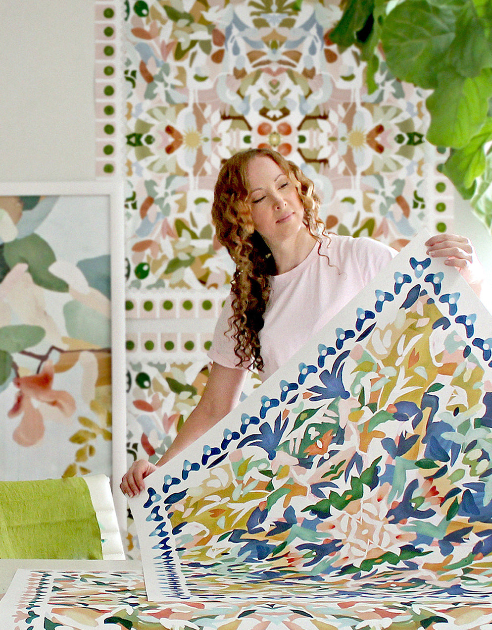 The artist arranging colorful large scale art prints in her art studio.