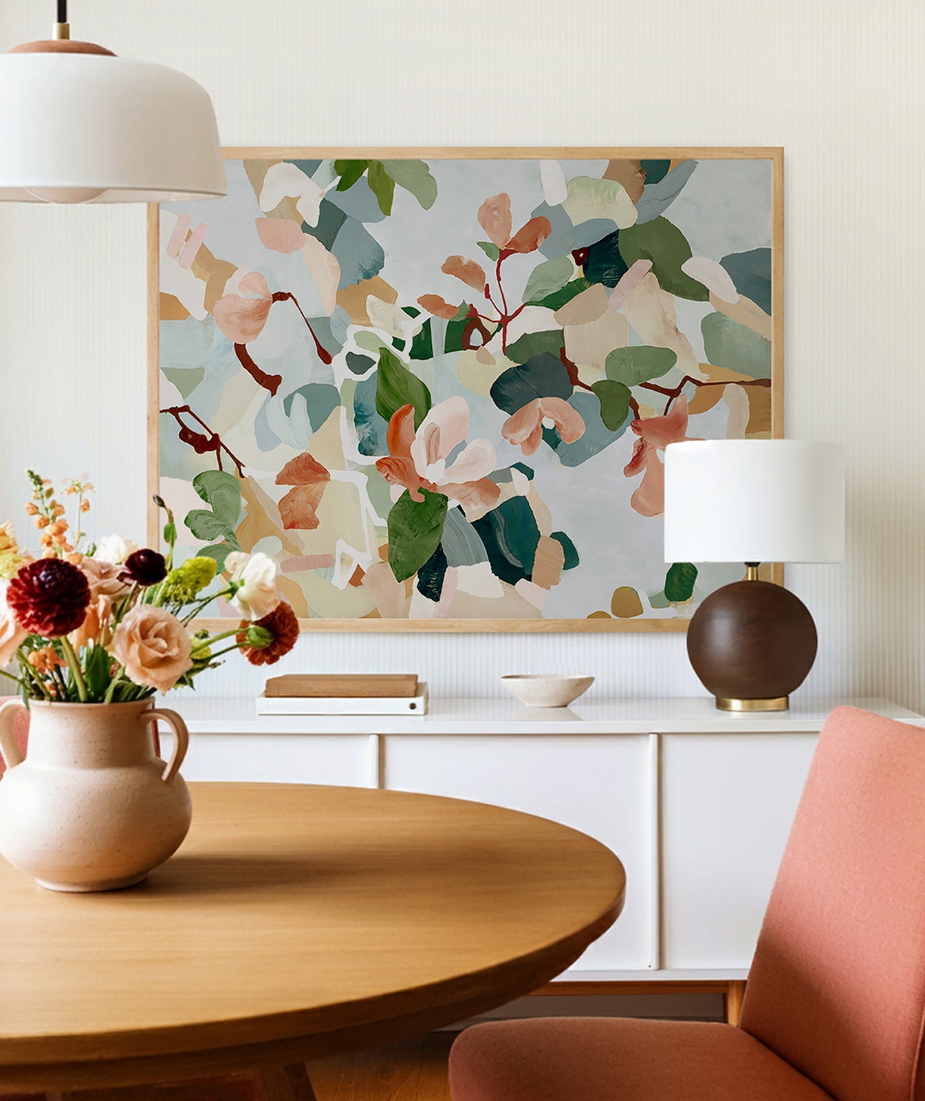 Large abstract floral art above a white cabinet in a feminine, mid century modern, dining room setting