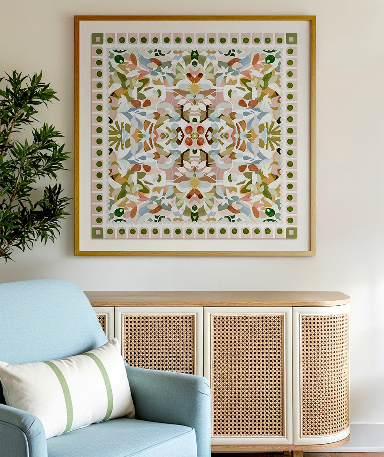 Decorative wall art with a floral symmetrical pattern in a wood frame above a cabinet in a living room.